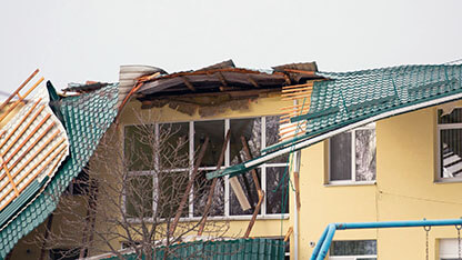 Damaged roof of a building. Strong wind, tornado, storm concept