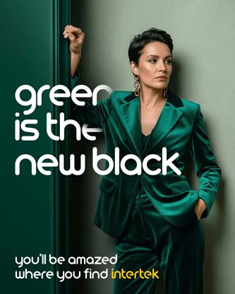 A woman wearing a green satin suit leaning against a wall