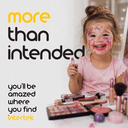 A young girl smiling with makeup and lipstick roughly drawn over her face